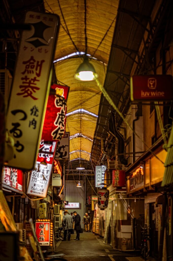 a narrow alley with signs hanging from the ceiling